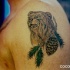 Ours brun avec une pomme de sapin tatouage sur l'épaule