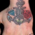 Ancora con diamante e rosa tatuati sulla mano