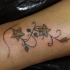 Une plante avec des fleurs le tatouage sur la cheville