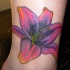 Une fleure tatouage sur la cheville en rose et pourpre