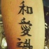 Scrittura asiatica tatuata sul braccio