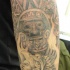 Le tatouage d'une déité aztèque avec un guerrier sur le bras