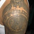 Tatuaje en el hombro en tracería azteca blanca y negra.