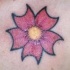 Tatuaggio colorato sul petto il fiore rosa