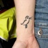Tatuaje en la mano, silueta de ave diminuto