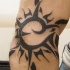 nero sole tribale trafori tatuaggio