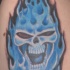 Calavera maligna en las llamas tatuaje en tinta azul