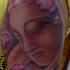Le tatouage de Bouddha en pierre dans les fleurs