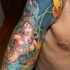 Tatuaje en color elementos búdicos en la manga
