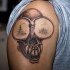 cranio con grandi occhi tatuaggio sulla spalla