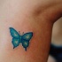 farfalla blu quasi invisibile tatuaggio