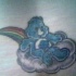orsetto blu sorridente sulla nuvola e arcobaleno tatuaggio