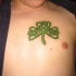 Tattoo von grünem Kleeblatt auf der Brust