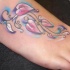 Ramo con i fiori colorati tatuato sul piede