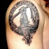 mano con arma emblema tatuaggio