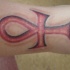 ankh rosso tatuaggio sul braccio