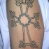 tatuaje en el brazo de tracería de cruz