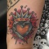 Le tatouage coloré de cœur couronné sur le poignet