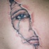 el tatuaje con una cara llorando detras de una rotura de piel