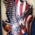 el tatuaje de la aguila con la bandera americana hecho en color en el brazo