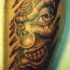 tatuaje de payaso malvado mirando a través de piel rasgada