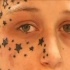 Tatuaggio polvere di stelle sul viso