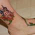 Tatuaje a color de una hada sentada en rosa