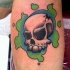 Tatuaje de una calavera con colores verde azul cerca
