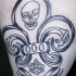 Le tatouage de fleur de lys avec une crâne et une inscription bois moi