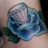 el tatuaje de una rosa azul con un diamante en el centro hecho en el cuello