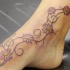 Pequeño tatuaje de la vid con camomila en el pie
