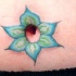 Tatuaje alrededor del ombligo de una flor azul