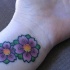 Dos flores pequeñas en color tatuaje en la muñeca