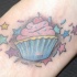 Tatuaggio colorato sul piede un dolcetto e le stelle