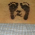 Le tatouage de bas du dos avec empreintes de pieds