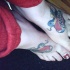 Tatuajes semejantes en los pies, aves en los corazones rojos