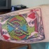 La carta da gioco il re di cuori tatuata sul braccio