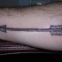 Tatuaje en el antebrazo, flecha larga simple