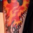 Il fuoco in forma di uccello tatuato sul braccio