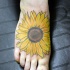 Un gros tatouage d'hélianthe sur le pied