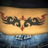 tatuaje en el bajo de la espalda de la tracería de tribal rojo y negro