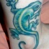 El tatuaje de una lagartija de color verde en la pierna