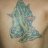 el tatuaje de las manos orantes de un zombie