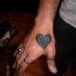 Grande cuore nero tatuato sulla mano