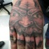 Tatuaje en la mano, monstruo con colmillos afilados
