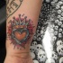 Le tatouage de cœur couronné sur la poignet