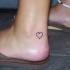 Piccolo cuore nero tatuaggio sul piede