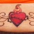 Le tatouage de cœur en flamme avec l'entrelacs