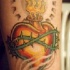 Le tatouage de cœur enflammé en couronne d
