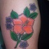 tatuaje de hibisco naranja con flores moradas